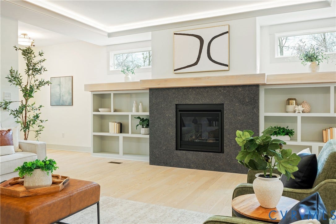 8919 Rustic Road, Richmond, VA 23235 Living space featuring a central fireplace with dark stone surround and a light wood mantel