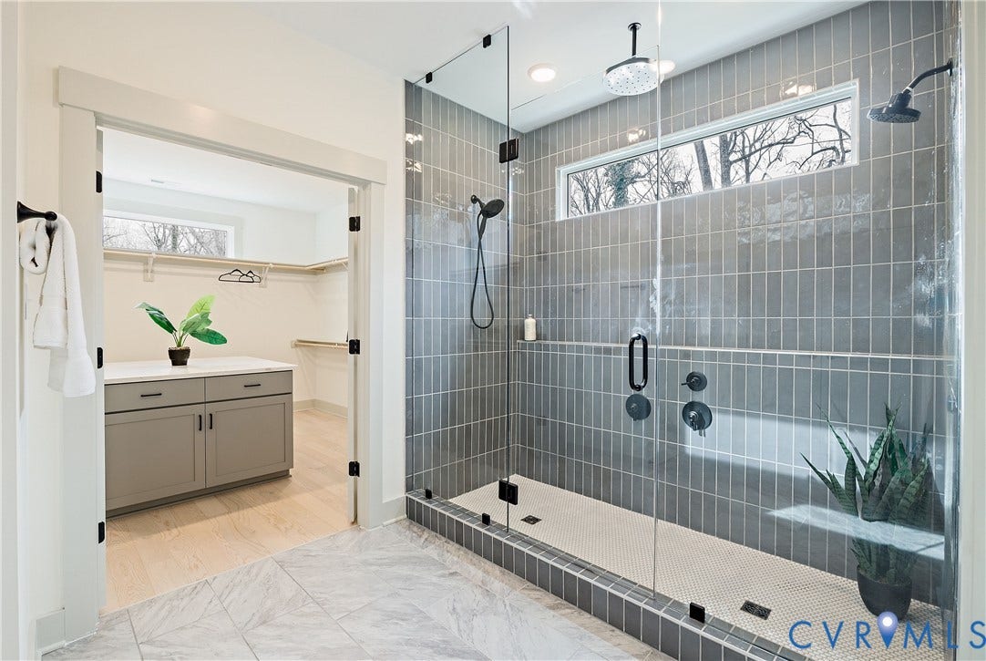 8919 Rustic Road, Richmond, VA 23235 Walk-in shower featuring full glass enclosure, vertical subway tile, dual shower heads, and a linear transom window