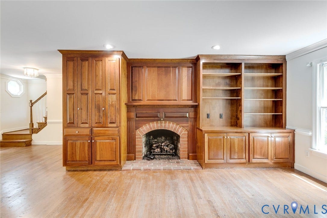 Built-in fireplace with brick surround, rich wood mantel, and integrated cabinetry