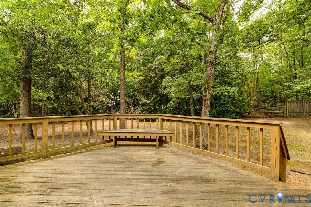 Spacious wood deck featuring built-in bench seating and a surrounding balustrade