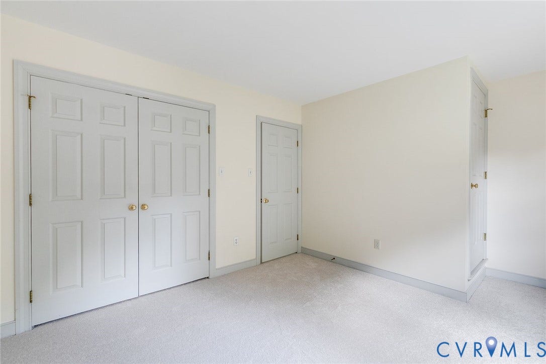 Bedroom with new carpet, generous closets, and a walk-up attic for easily accessible storage.