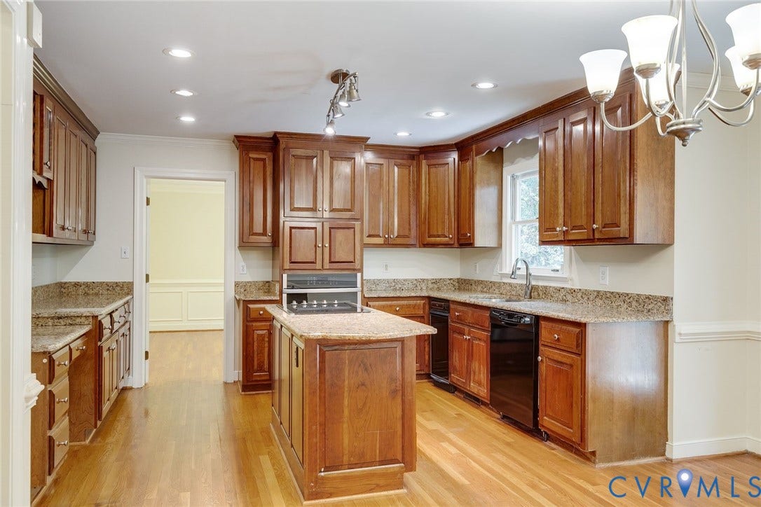 Kitchen featuring wood cabinetry, granite-style countertops, an island with a built-in cooktop, recessed lighting, and wood-finish flooring