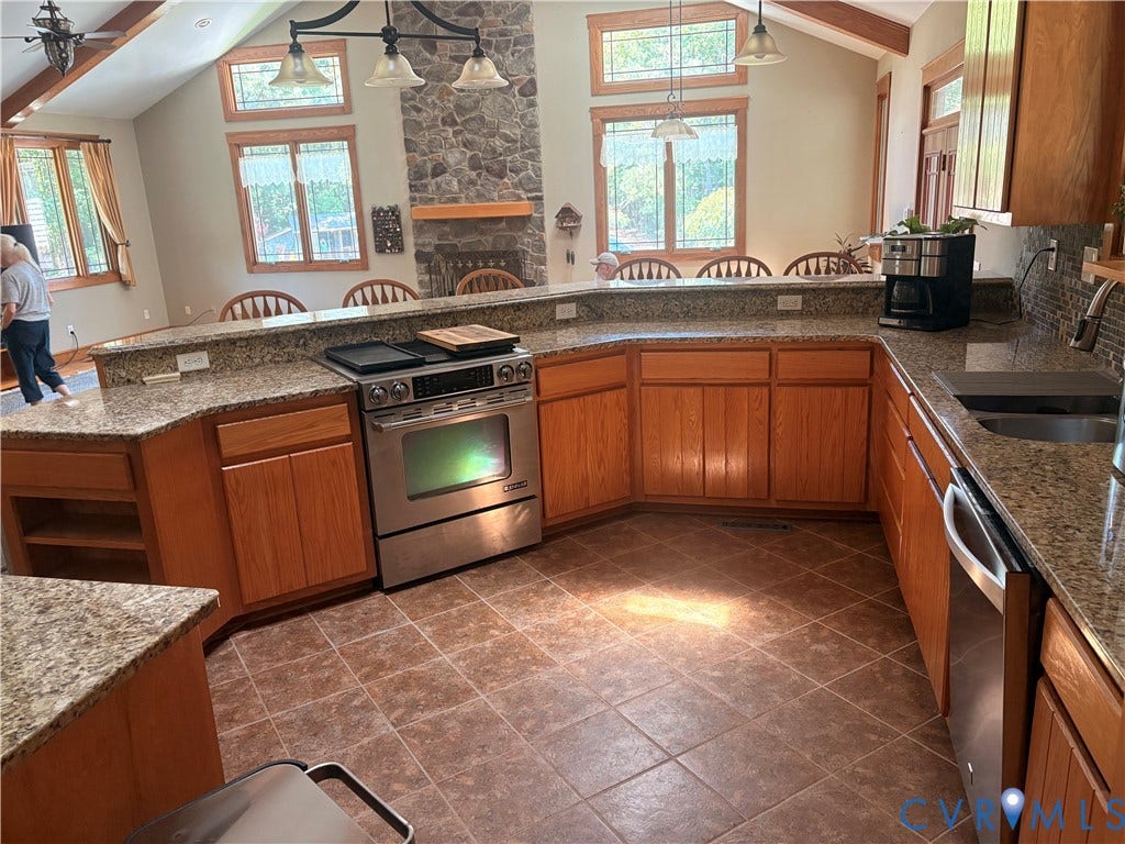 Kitchen featuring U-shaped counter with a built-in range, stainless steel dishwasher, and an undermount sink