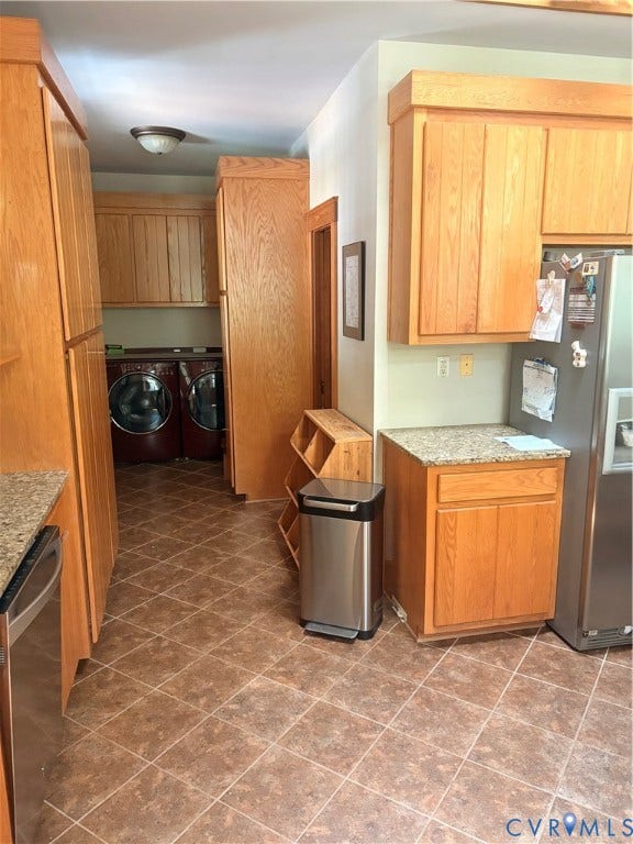 Kitchen area featuring abundant wood cabinetry, granite countertops, stainless steel appliances, and diagonal tile flooring