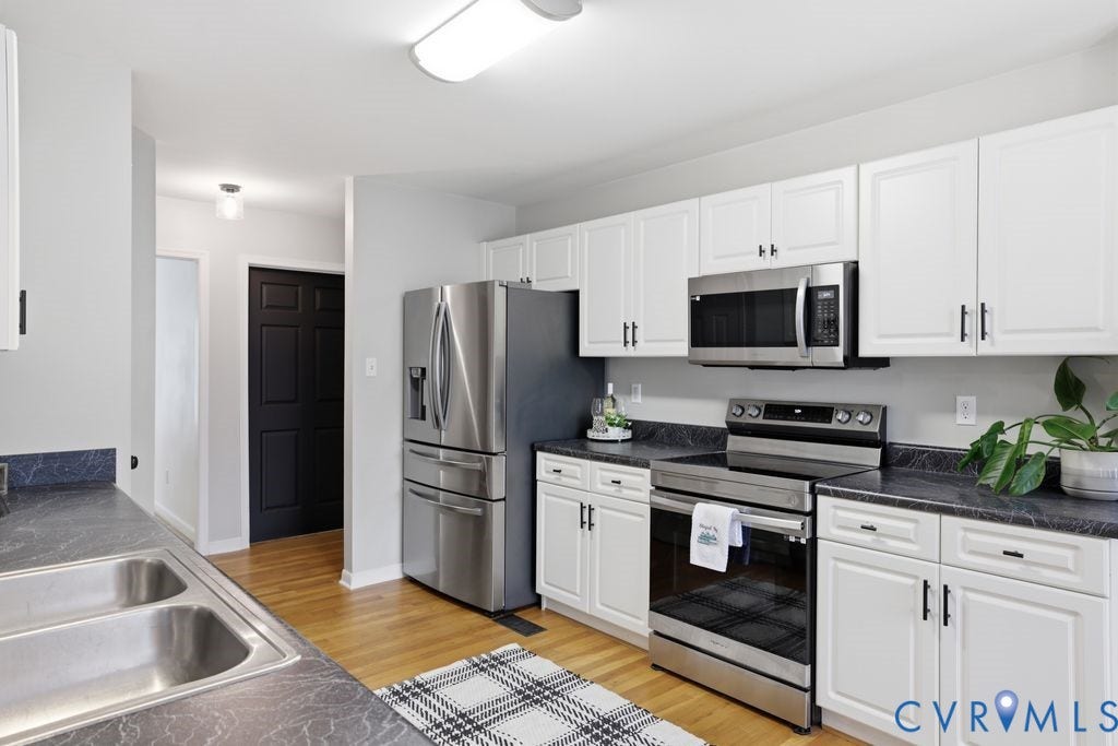 3819 Daniels Street, Chesterfield, VA 23831 Kitchen featuring white cabinetry with dark hardware, dark patterned countertops, stainless steel appliances, and wood-finish flooring