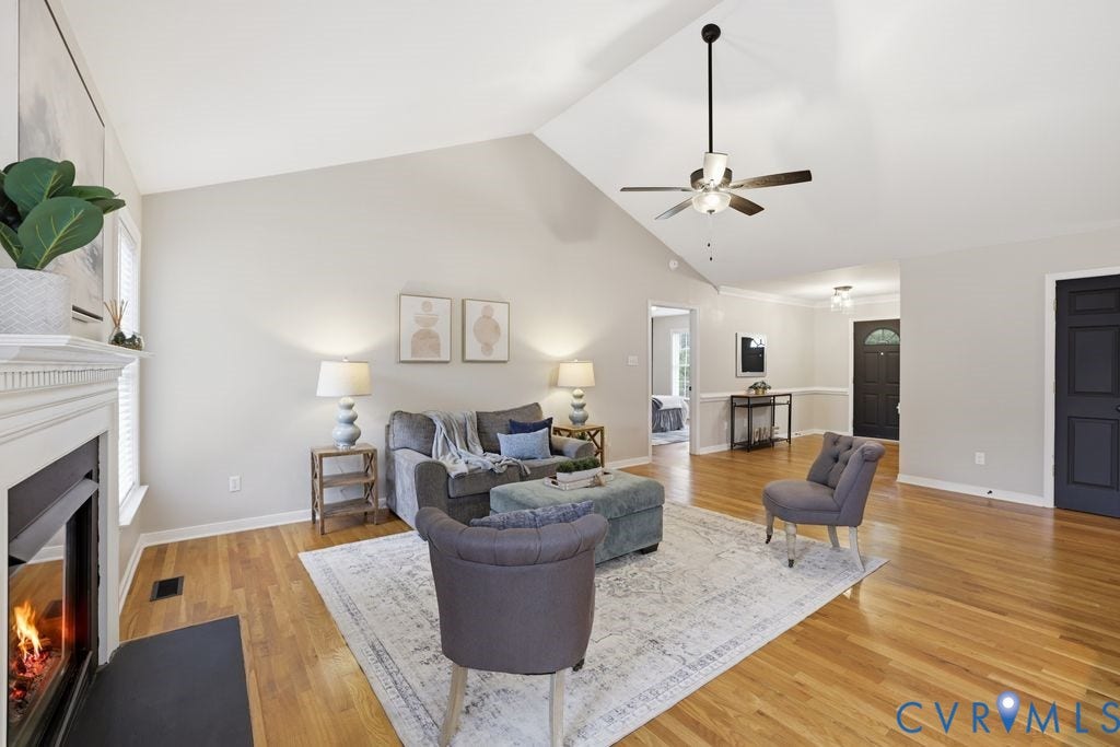 3819 Daniels Street, Chesterfield, VA 23831 Spacious living area featuring vaulted ceilings, wood-finish flooring, a white mantel fireplace, ceiling fan, and painted interior doors