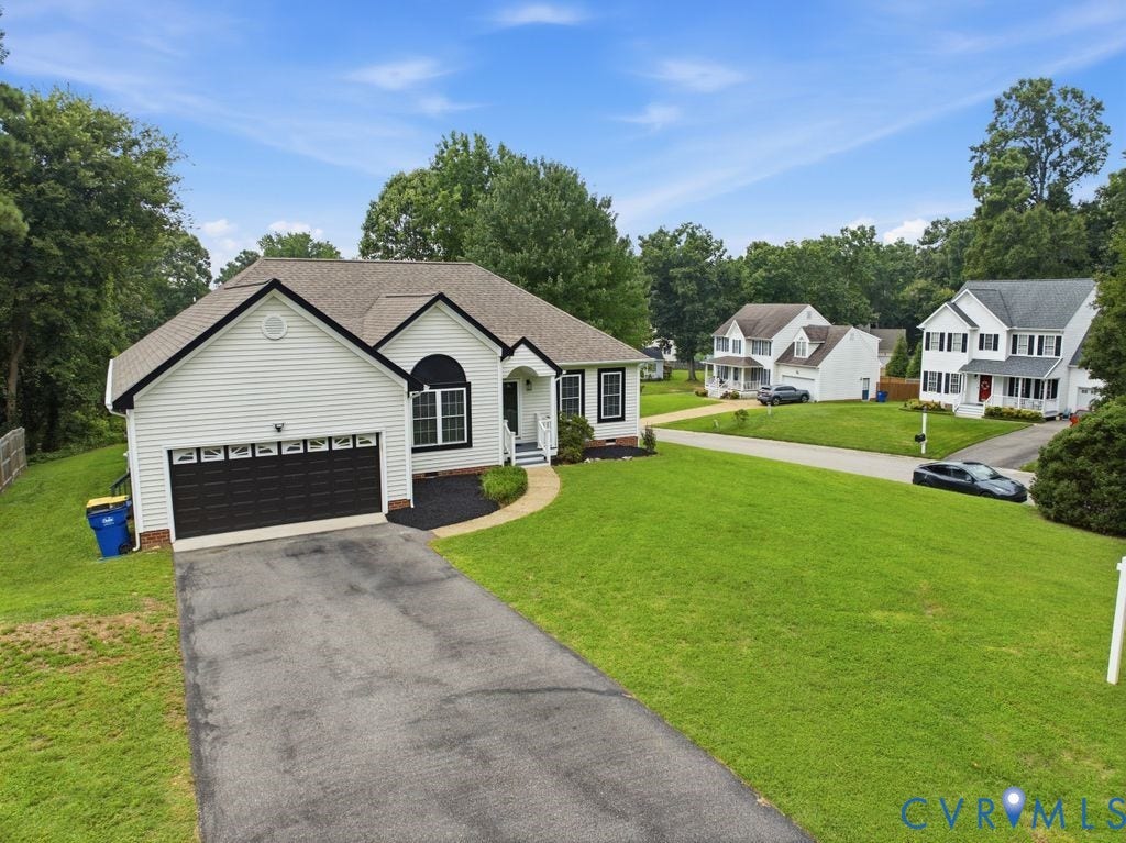 3819 Daniels Street, Chesterfield, VA 23831 White siding exterior featuring a dark brown garage door, arched window, and front porch
