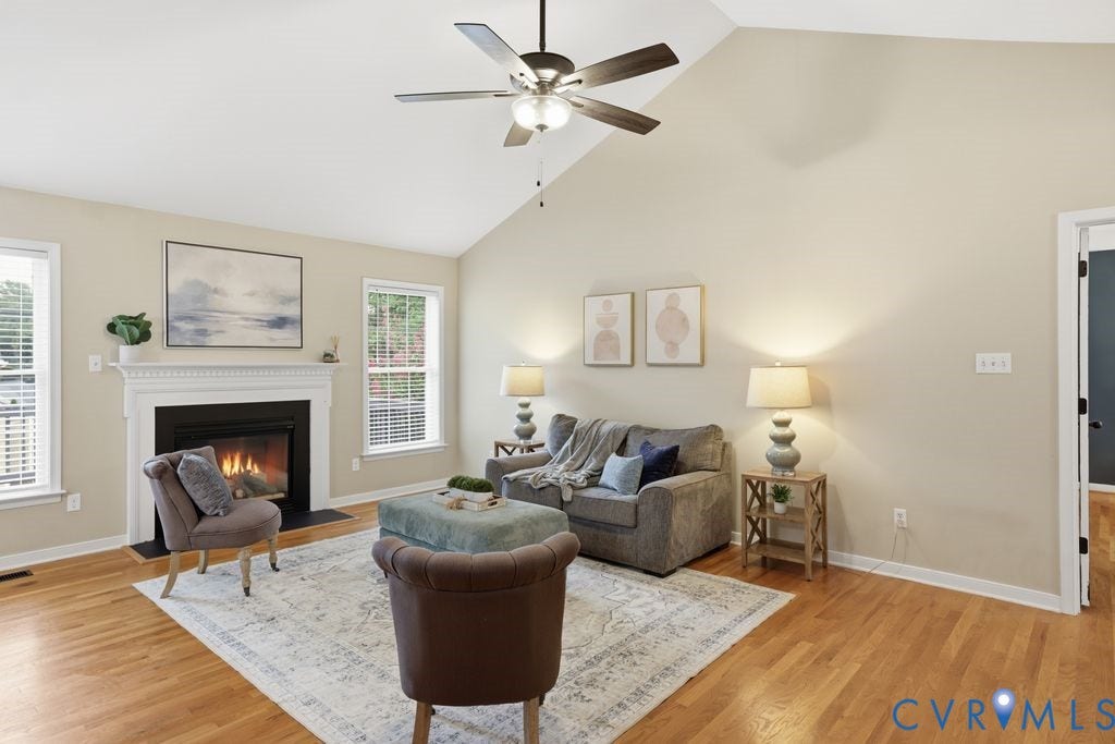 3819 Daniels Street, Chesterfield, VA 23831 Living area featuring a vaulted ceiling with a ceiling fan, hardwood flooring, and a fireplace with a white mantel