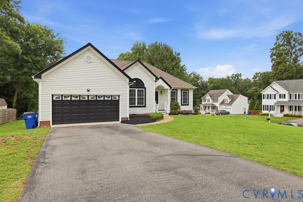 3819 Daniels Street, Chesterfield, VA 23831 White siding exterior with black trim accents and a dark gray garage door