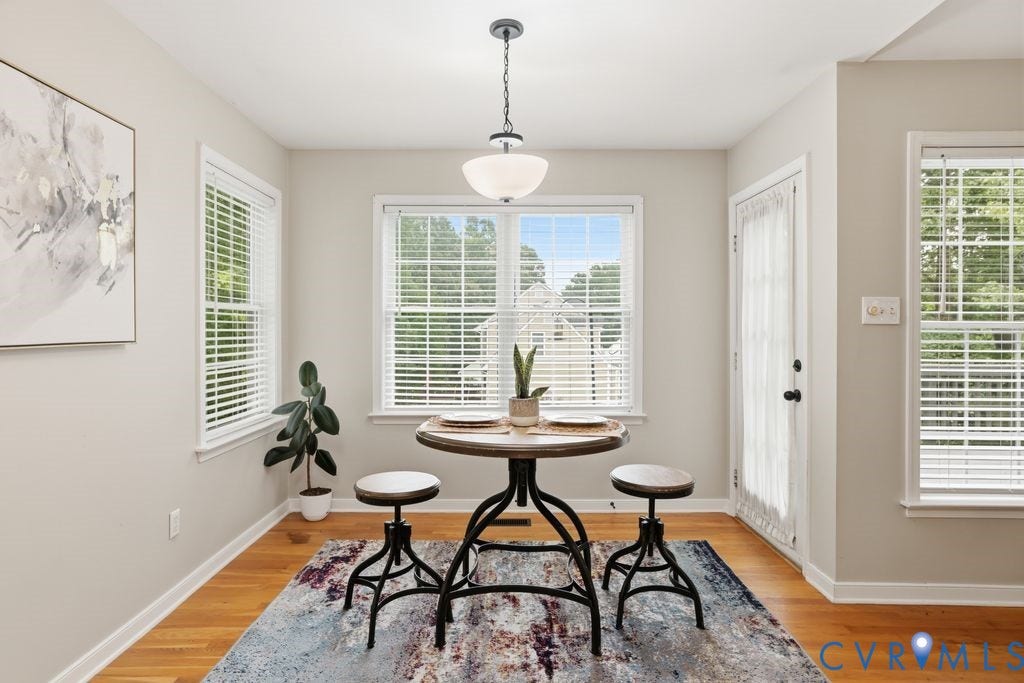 3819 Daniels Street, Chesterfield, VA 23831 Compact dining area featuring hardwood flooring, multiple windows with blinds, a full-light exterior door, and a semi-flush mount ceiling fixture