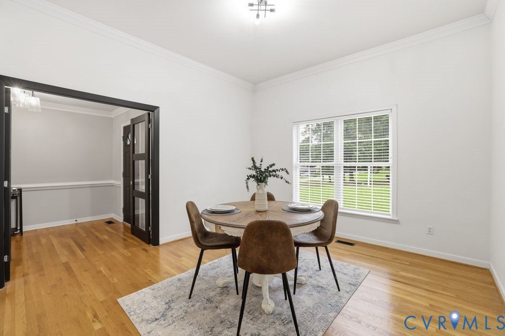 3819 Daniels Street, Chesterfield, VA 23831 Dining area featuring hardwood flooring, crown molding, a large window with blinds, and a doorway with dark-framed French doors