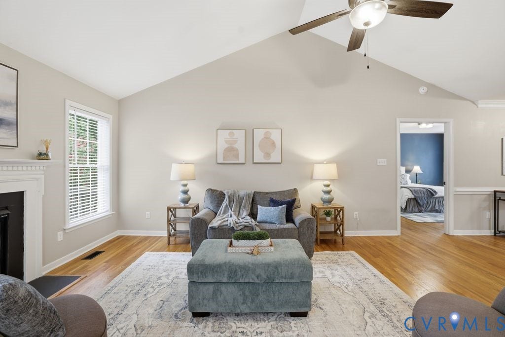 3819 Daniels Street, Chesterfield, VA 23831 Living area featuring a vaulted ceiling with a ceiling fan, hardwood flooring, and a fireplace with a white mantel