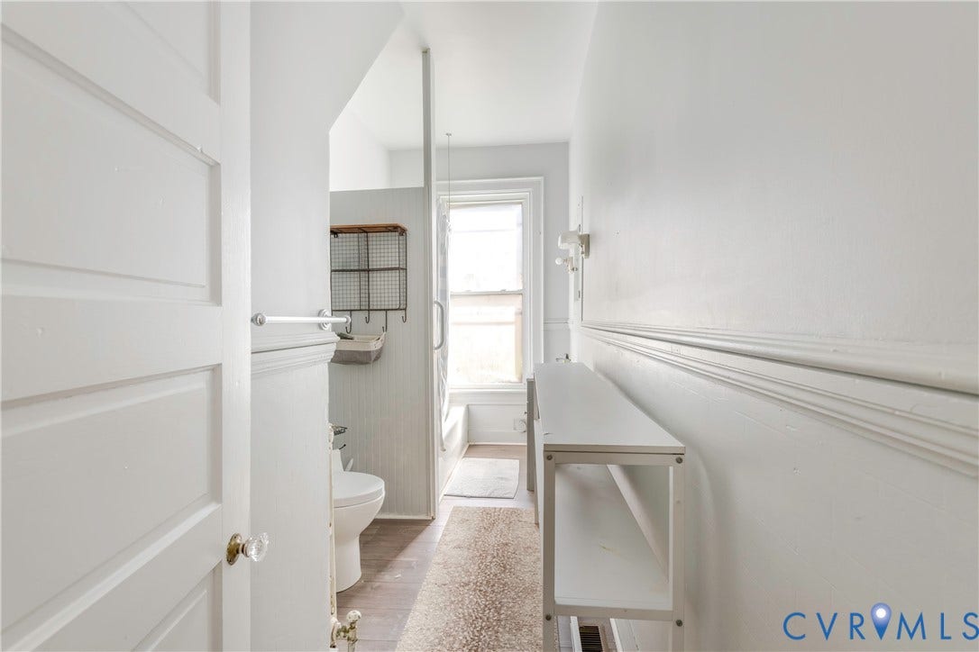 4404 Patterson Avenue, Richmond, VA 23221 Bathroom featuring a paneled door with clear knob hardware, wainscoting, and wood-finish flooring