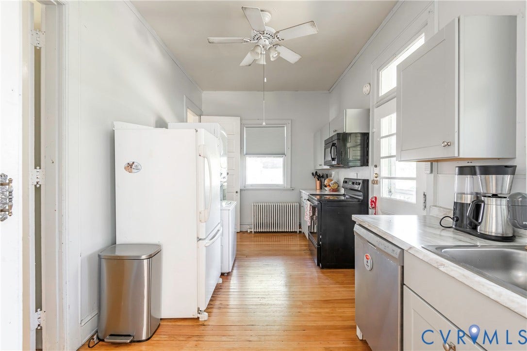 4404 Patterson Avenue, Richmond, VA 23221 Galley kitchen featuring wood-finish flooring, white cabinetry, light countertops, and a stainless steel sink