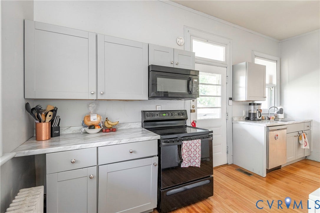 4404 Patterson Avenue, Richmond, VA 23221 Kitchen featuring light gray cabinetry, a black range, an over-the-range microwave, wood-finish flooring, and a single-basin sink with a stainless steel dishwasher