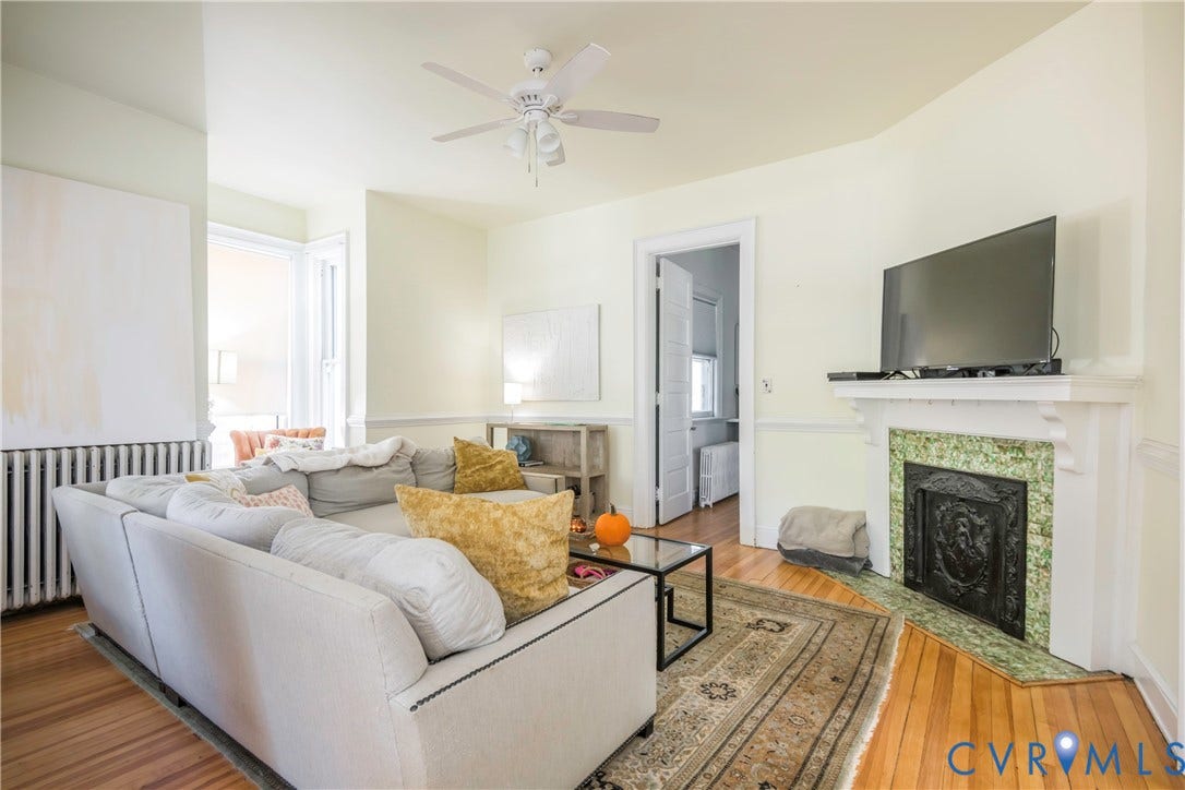 4404 Patterson Avenue, Richmond, VA 23221 Living area featuring wood-finish flooring, a decorative fireplace with green stone surround, and a ceiling fan
