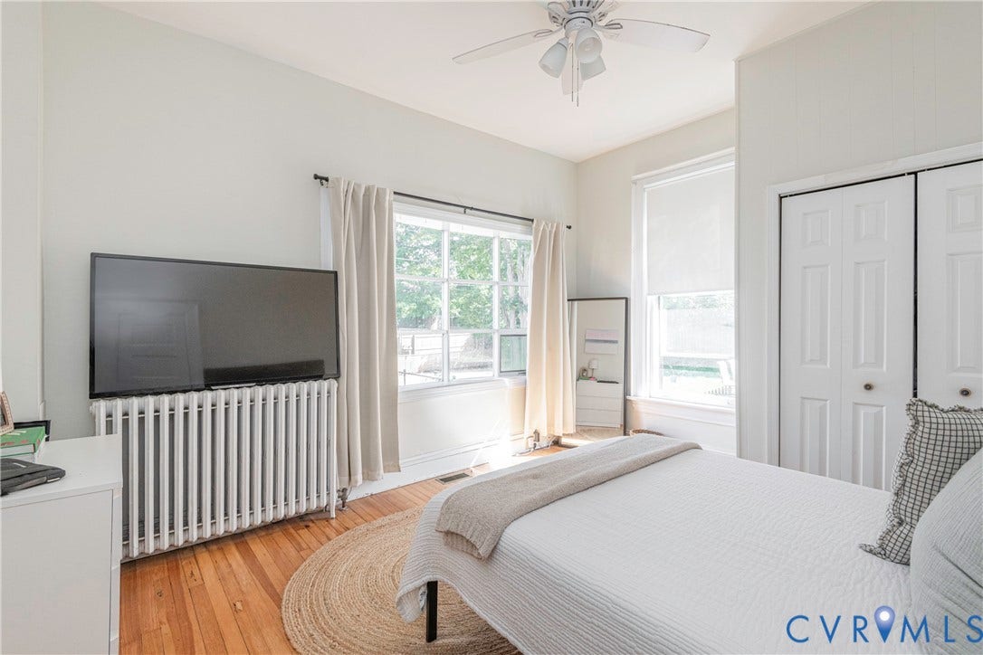 4404 Patterson Avenue, Richmond, VA 23221 Bedroom featuring polished wood flooring, a ceiling fan with integrated lighting, window treatments, and bi-fold closet doors