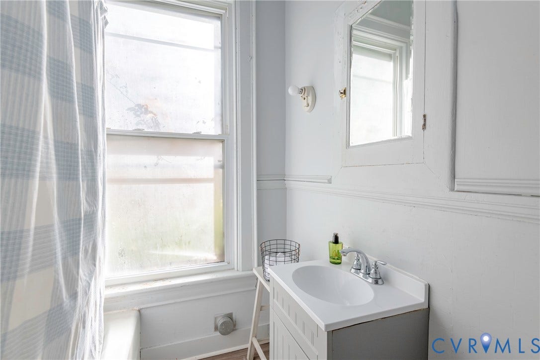 4404 Patterson Avenue, Richmond, VA 23221 Bathroom featuring a single-pane window, single vanity with integrated sink, and white wall paneling