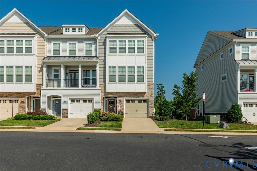 10414 Perennial Drive, Henrico, VA 23233 Contemporary townhome elevation featuring a stone facade accent, light gray siding, a private balcony, and an attached two-car garage