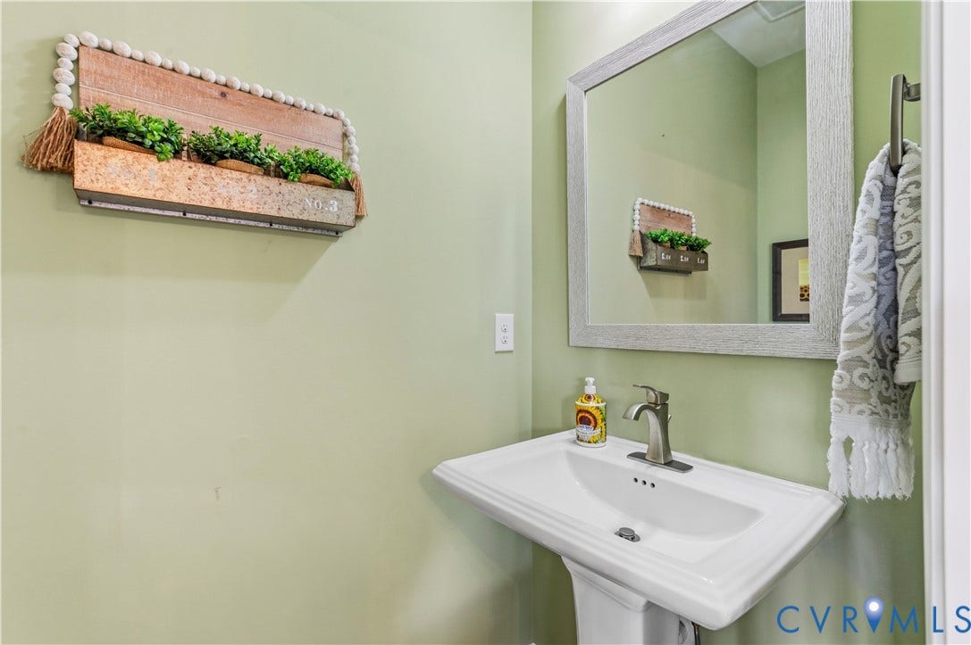 10414 Perennial Drive, Henrico, VA 23233 Pedestal sink with a brushed nickel faucet, framed mirror, and a wall-mounted towel bar