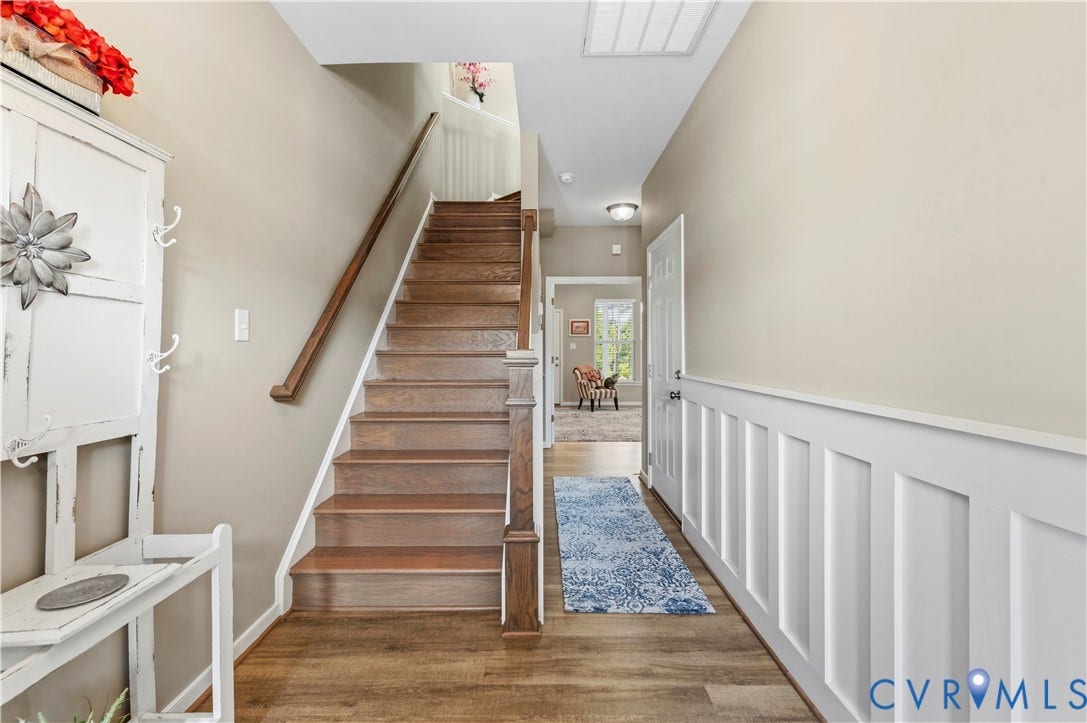 10414 Perennial Drive, Henrico, VA 23233 Entryway featuring wood-finish flooring, a staircase with wood treads and handrail, neutral wall paint, and white board and batten paneling
