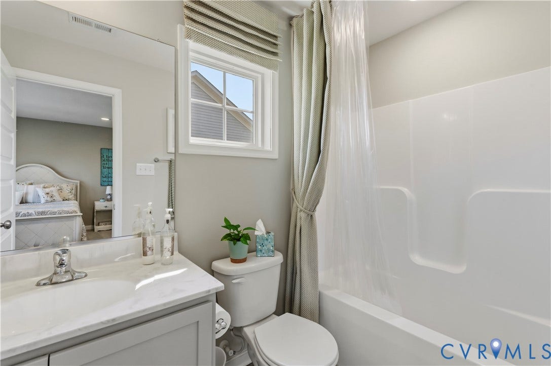 10414 Perennial Drive, Henrico, VA 23233 Bathroom featuring a white integrated tub and shower unit, a single vanity with a marble-finish countertop, and a window with horizontal blinds