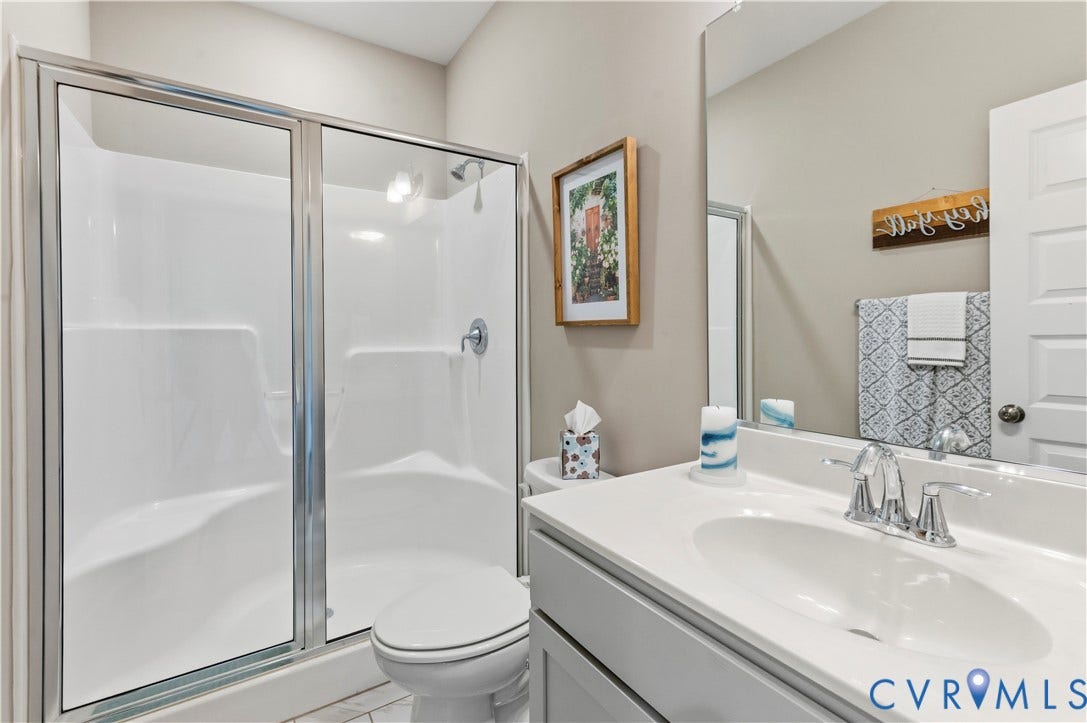 10414 Perennial Drive, Henrico, VA 23233 Bright full bathroom featuring a white vanity with integrated sink, chrome faucet, and a large mirror