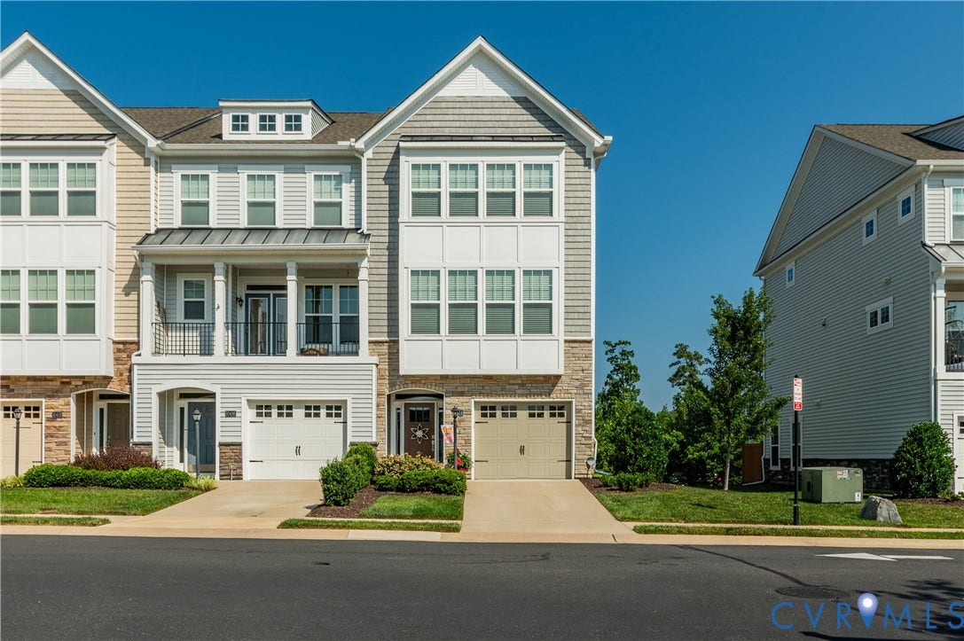 10414 Perennial Drive, Henrico, VA 23233 Three-story townhome featuring a two-car garage, upper-level balcony, and dormer window