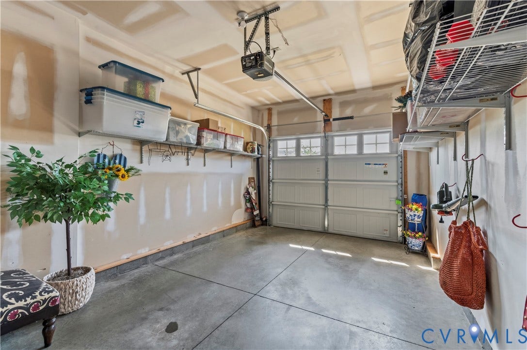 10414 Perennial Drive, Henrico, VA 23233 Garage featuring a sectional overhead door with upper window inserts, concrete flooring, and an automatic garage door opener