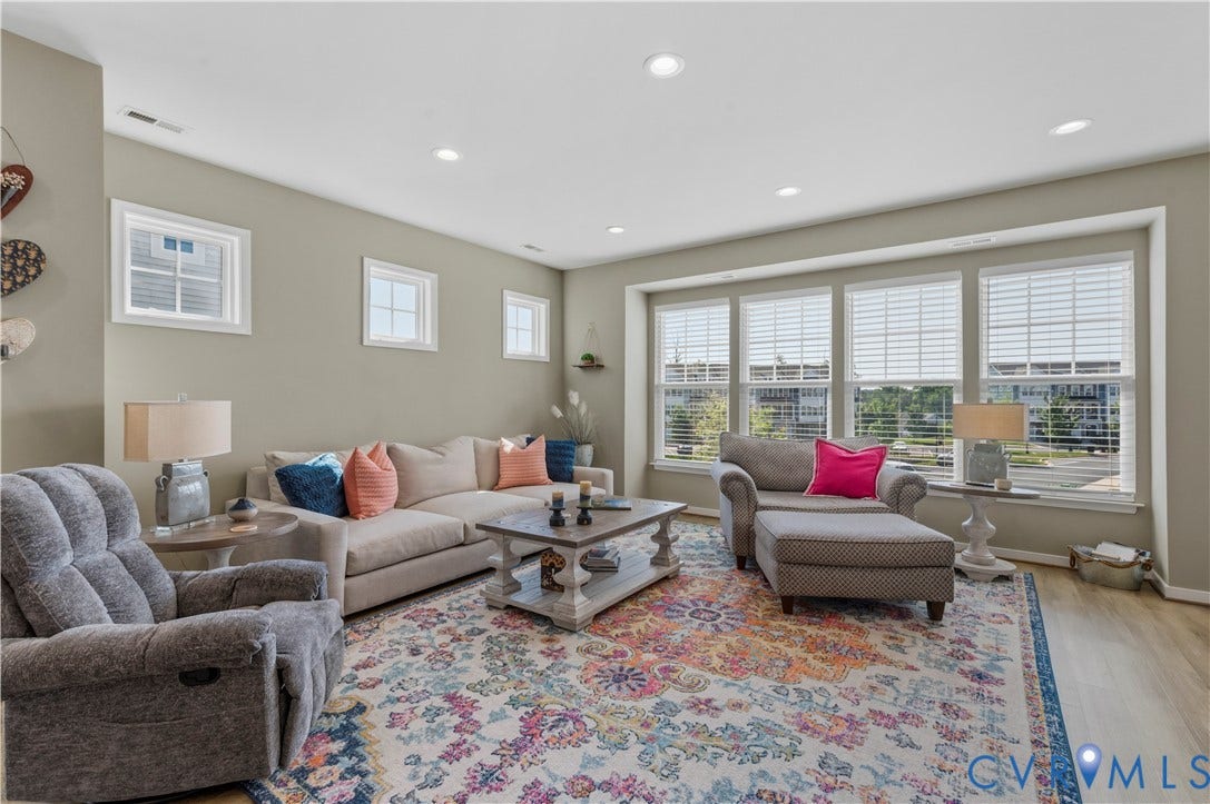 10414 Perennial Drive, Henrico, VA 23233 Living area with recessed ceiling lighting, light wood-finish flooring, and a large window wall featuring multiple double-hung windows with blinds
