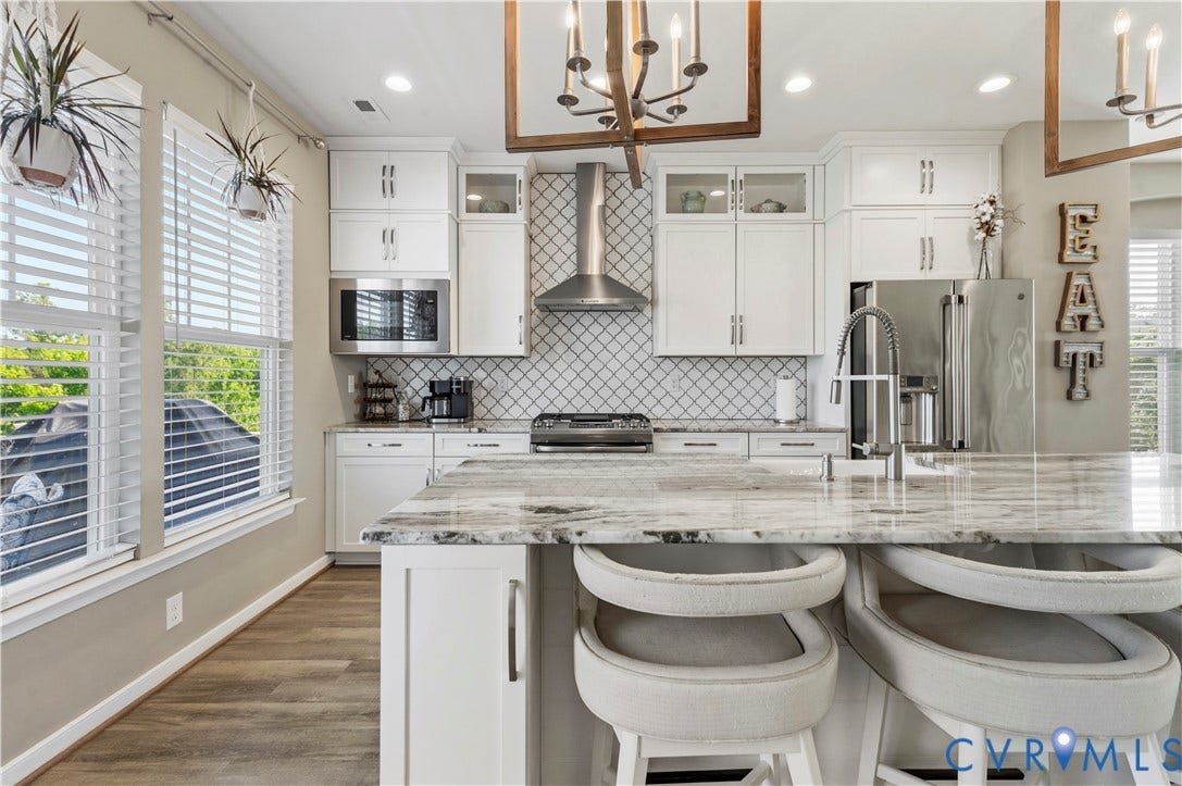 10414 Perennial Drive, Henrico, VA 23233 Kitchen featuring an oversized island with a polished stone countertop, stainless steel appliances, white cabinetry, a tiled backsplash, and wood-finish flooring