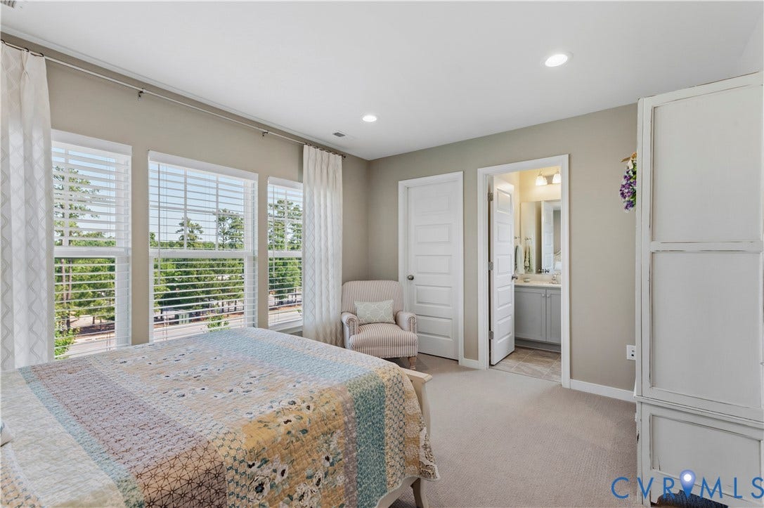 10414 Perennial Drive, Henrico, VA 23233 Interior room with three large windows, recessed ceiling lighting, light-toned carpeting, and an adjoining bathroom featuring a vanity with a rectangular sink and a wall-mounted light fixture