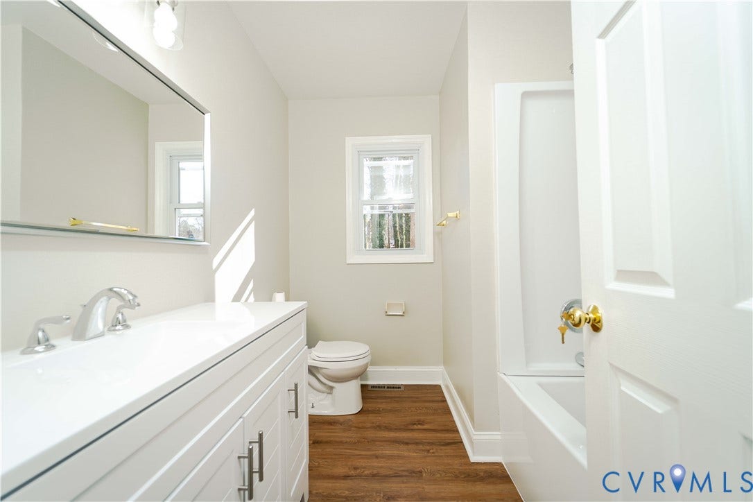 3025 Maplevale Road, Chester, VA 23831 Bathroom featuring a white vanity with integrated sink, chrome faucet, and wood-finish flooring