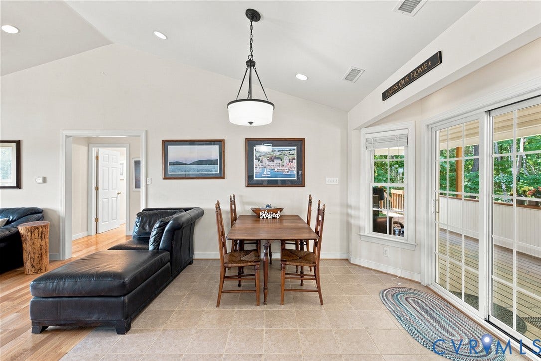 Vaulted ceiling with recessed lighting and a central chandelier