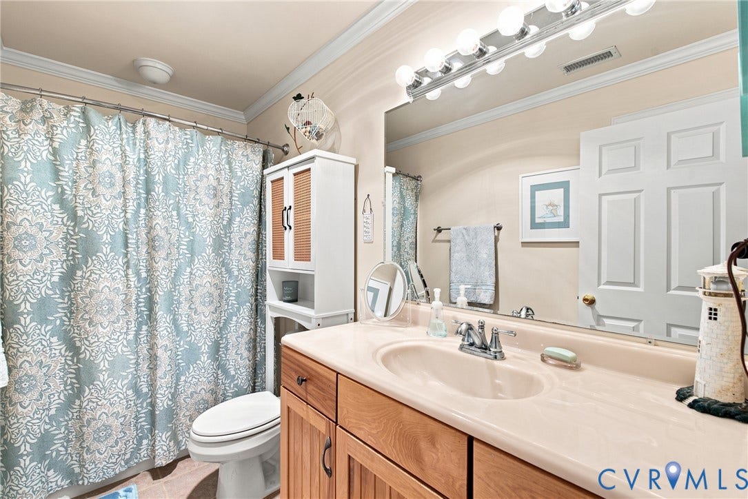 Bathroom vanity with a light-colored countertop, integrated sink, and chrome faucet