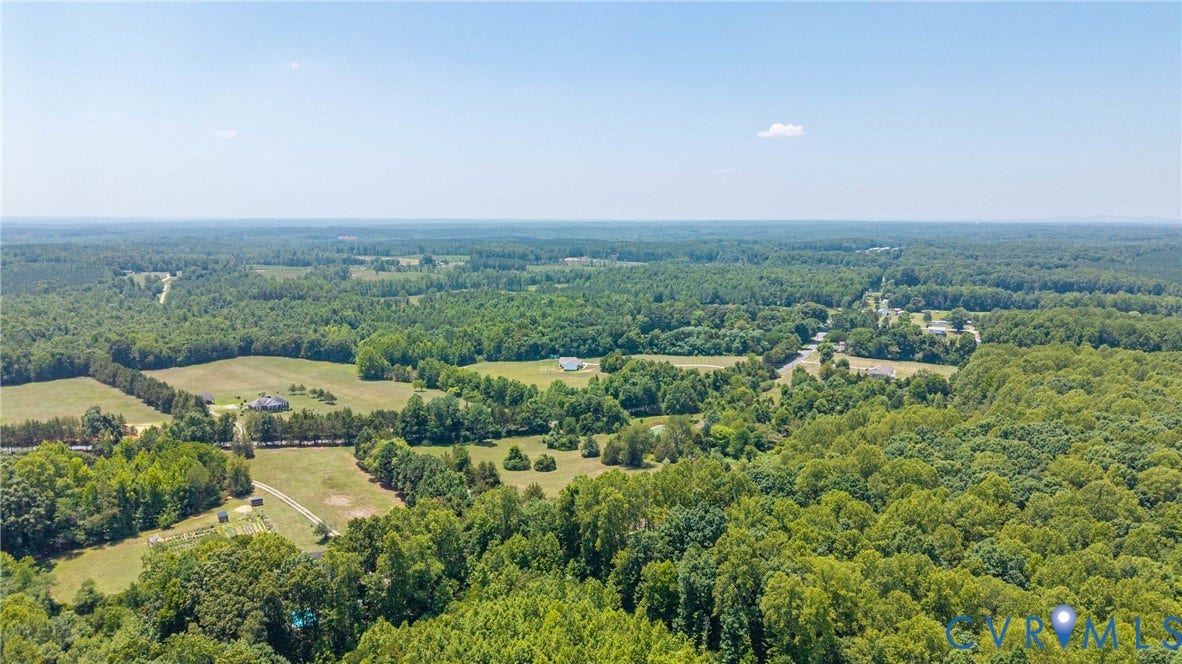 Expansive property featuring a blend of wooded areas and open fields