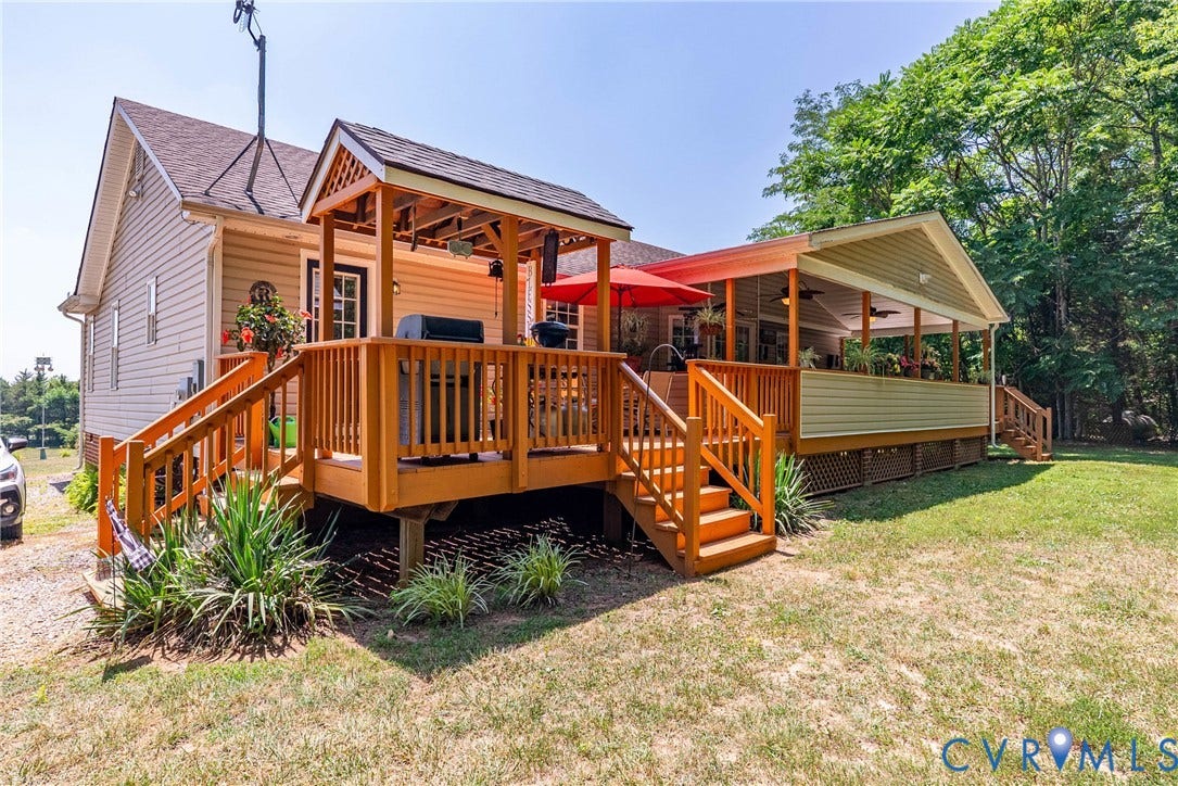 Expansive outdoor living featuring a multi-level wood deck, a covered porch, and a separate covered gazebo