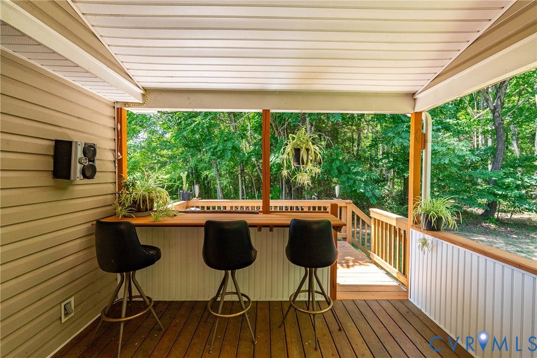 Covered outdoor patio featuring wood-finish flooring, wood bar counter, and exterior siding