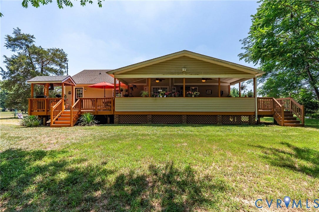 Expansive backyard featuring a covered patio, additional deck space, and multiple outdoor access points