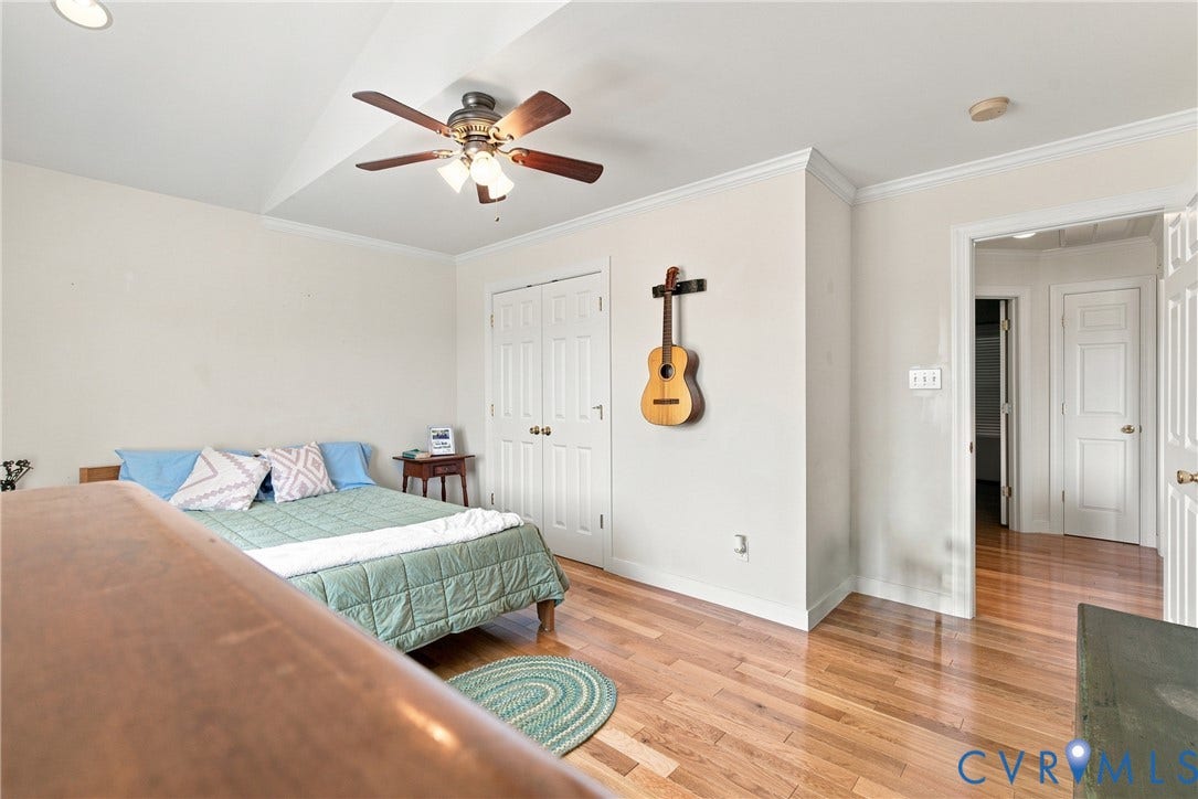 Bedroom featuring light wood-finish flooring, white trim, and a ceiling fan with integrated lighting