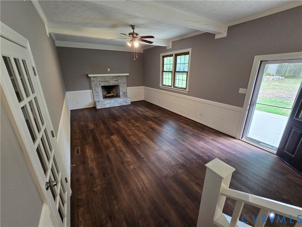 3901 Buckland Place, Chester, VA 23831 Spacious interior featuring wood-finish flooring, a stone-clad fireplace, and white wainscoting