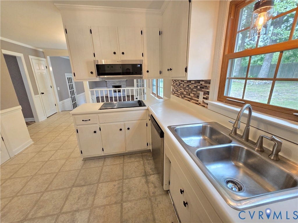 3901 Buckland Place, Chester, VA 23831 Kitchen featuring white cabinetry with black hardware, a dual basin stainless steel sink with a gooseneck faucet, a mosaic tile backsplash, and a built-in microwave