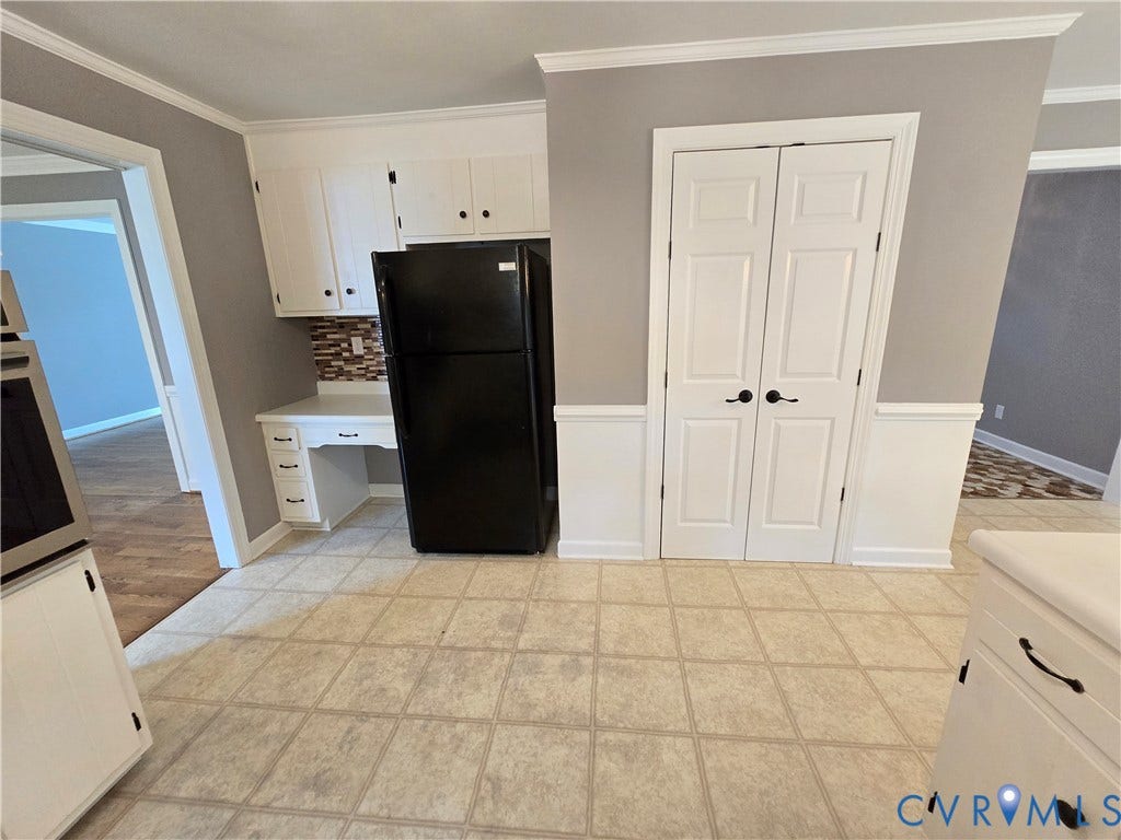 3901 Buckland Place, Chester, VA 23831 Kitchen area featuring a built-in desk, white cabinetry with black hardware, and a mosaic tile backsplash
