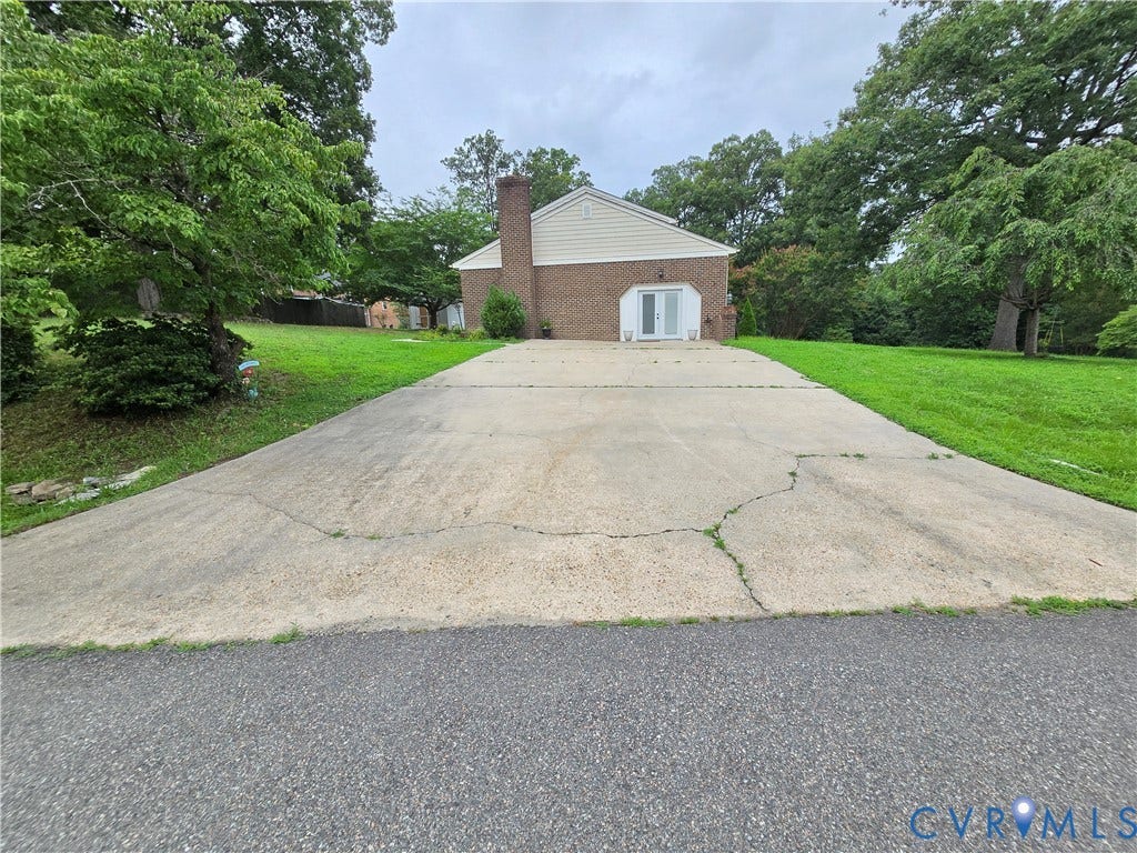 3901 Buckland Place, Chester, VA 23831 Brick exterior featuring a white gabled roofline and a large concrete driveway