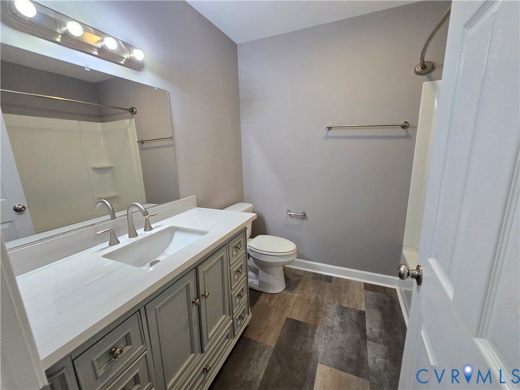 3901 Buckland Place, Chester, VA 23831 Hall Bathroom featuring a spacious vanity with a white countertop and double sinks, a large mirror, and wood-finish flooring