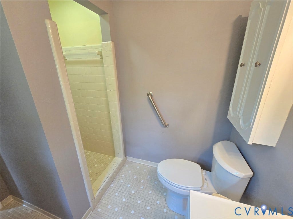 3901 Buckland Place, Chester, VA 23831 Bathroom featuring a walk-in shower with tile surround, white toilet, wall-mounted grab bar, white wall cabinet, and mosaic floor tile
