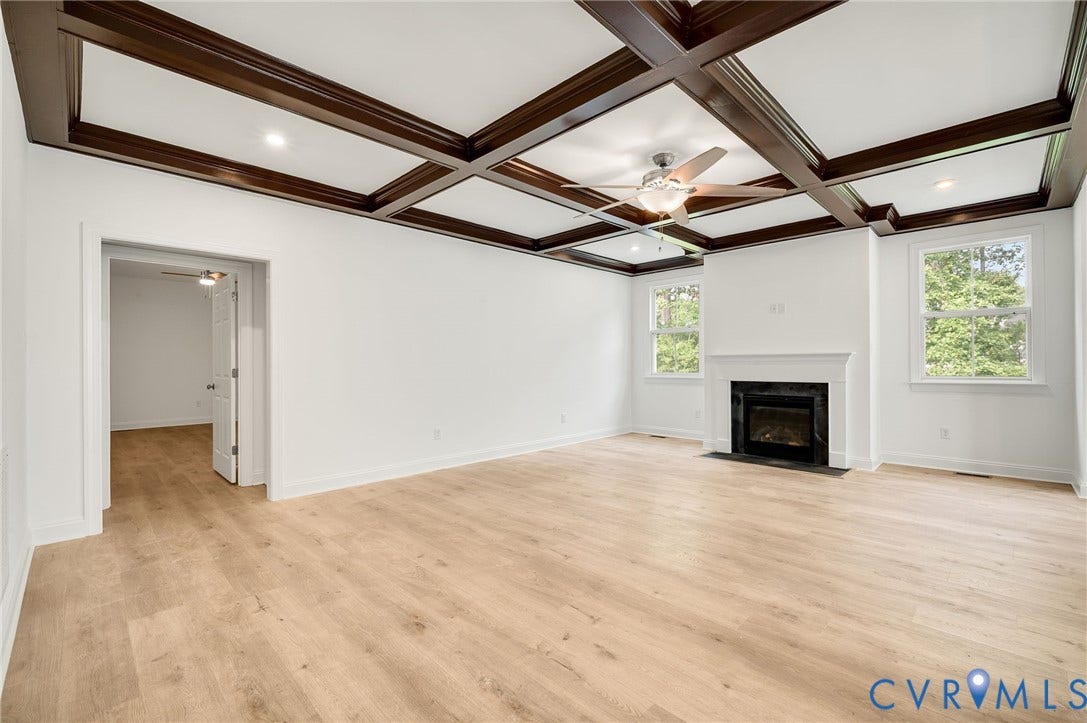 7130 Maple Summit Lane, Moseley, VA 23120 Living space featuring a coffered ceiling, wood-finish flooring, a fireplace with a white mantel, and two windows