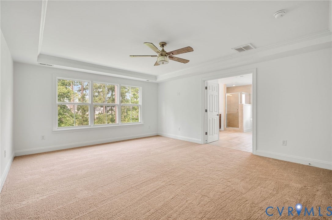 7130 Maple Summit Lane, Moseley, VA 23120 Spacious room featuring multiple windows, tray ceiling, crown molding, and a ceiling fan
