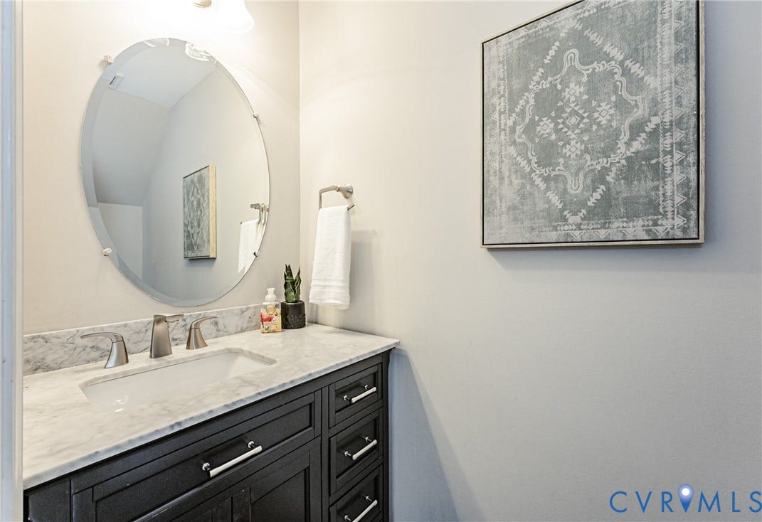 1324 Stone Ridge Park Loop, Henrico, VA 23228 Bathroom vanity featuring a dark wood-finish cabinet with silver-tone hardware, a white countertop, and an undermount sink