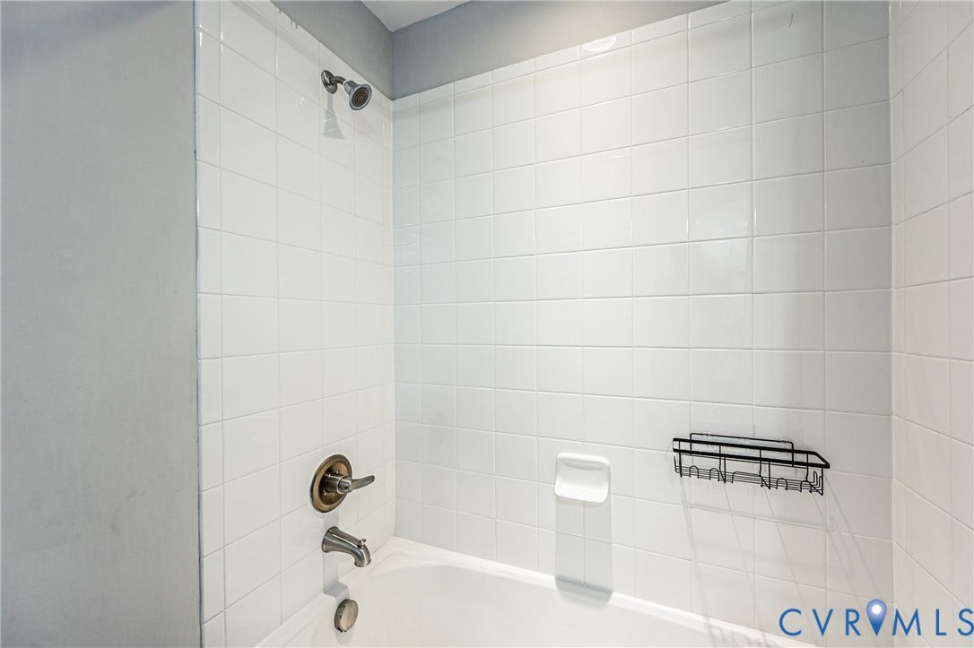 1324 Stone Ridge Park Loop, Henrico, VA 23228 Bathtub shower combination featuring white subway tile surround, bronze-finish fixtures, and a wall-mounted shower head